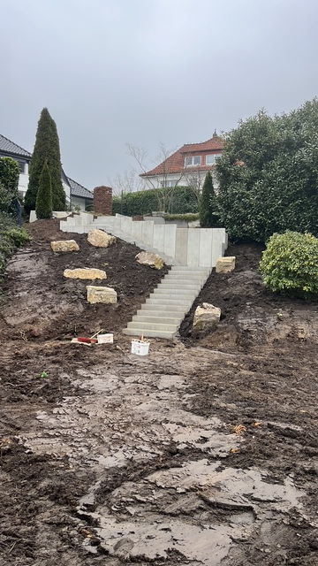 Slope retained with L-shaped concrete elements, concrete steps and shell limestone boulders during construction