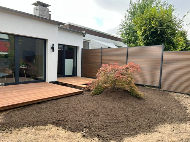 Timber deck with privacy fence and Japanese maple, ground prepared for lawn seeding