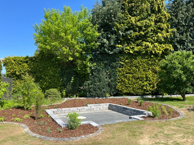 Finished seating area with walled edging, bark mulch bed and clipped hedges