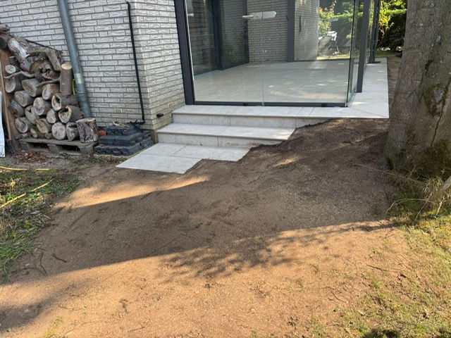 Terrace in light porcelain stoneware with block steps at a brick house
